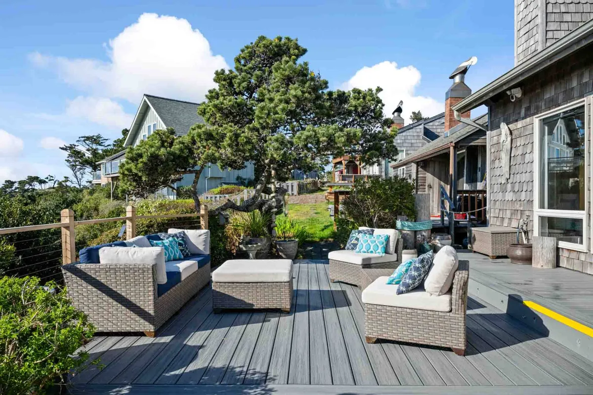 A calm and serene outdoor seating area surrounded by greenery and a decorative tree, perfect for relaxing or socializing. The ambiance is tranquil, with seating positioned to enjoy the outdoors, suggesting a peaceful retreat after a day out.