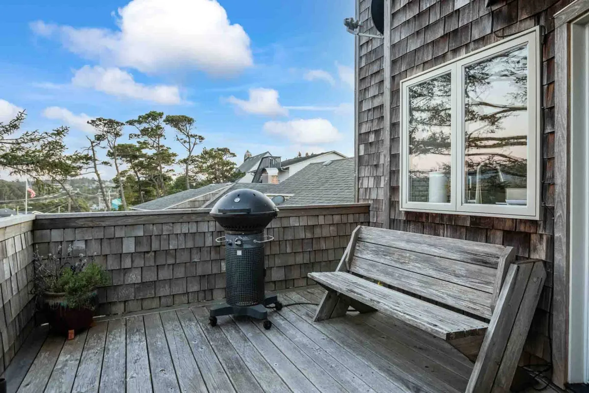 A relaxed outdoor area featuring a bench and grill, surrounded by plants and trees. The setup is ideal for leisurely barbecues, sunset dinners, or enjoying the stars in a casual, natural environment.
