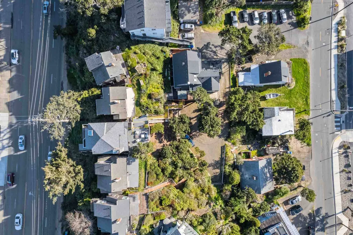 This exterior image features a vibrant neighborhood scene with houses, trees, driveways, cars, and clearly visible pathways. The image conveys a sense of walkability, community, and accessibility, aligning with the section’s theme of exploring local amenities on foot.